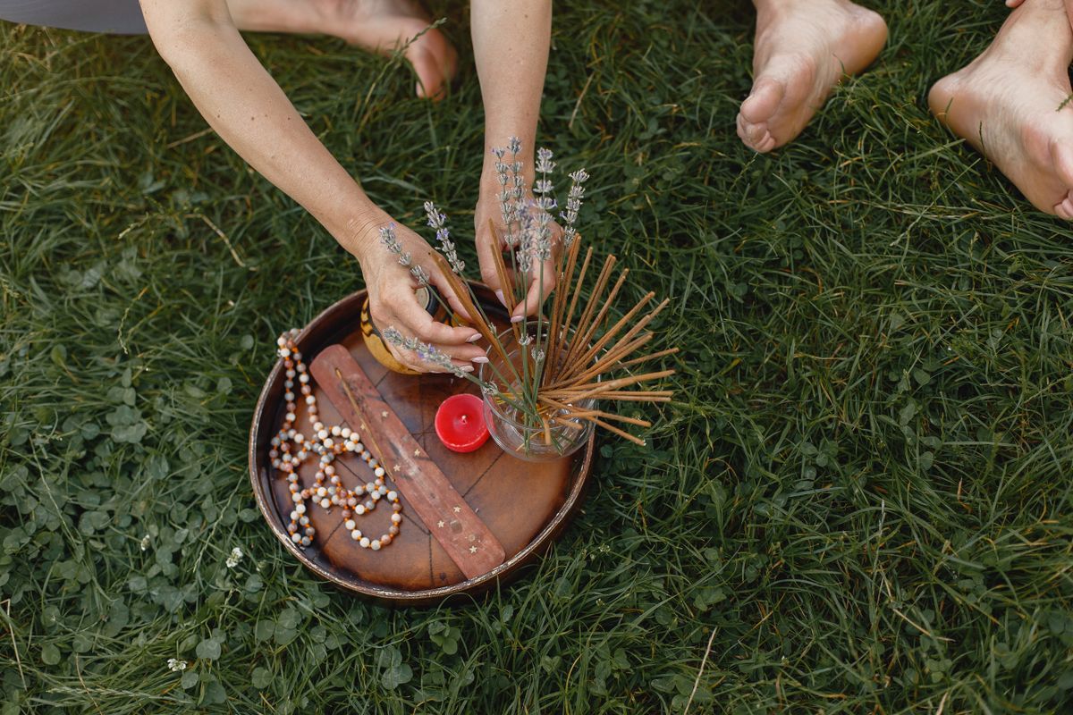 Incense sticks and flowers arranged on a glass cup